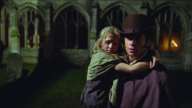 Young Cosette (Isabelle Allen) holds on tight to Jean Valjean (Hugh Jackman) in "Les Misérables" Universal Pictures